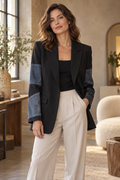 Imagen conceptual de Blazer negro con paneles efecto denim creada con IA; prenda pendiente de confirmar