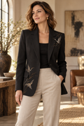 Imagen conceptual de Blazer negro con bordado de aves creada con IA; prenda pendiente de confirmar