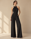 Imagen conceptual de Mono negro de cuello halter y pernera ancha creada con IA; diseño pendiente de confirmar.