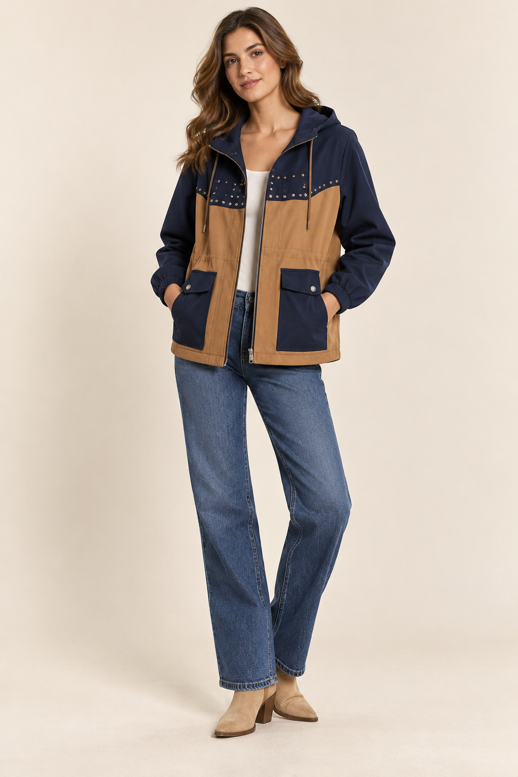 Imagen conceptual generada por IA de chaqueta bicolor azul marino y camel con capucha y bolsillos; no representa el artículo definitivo