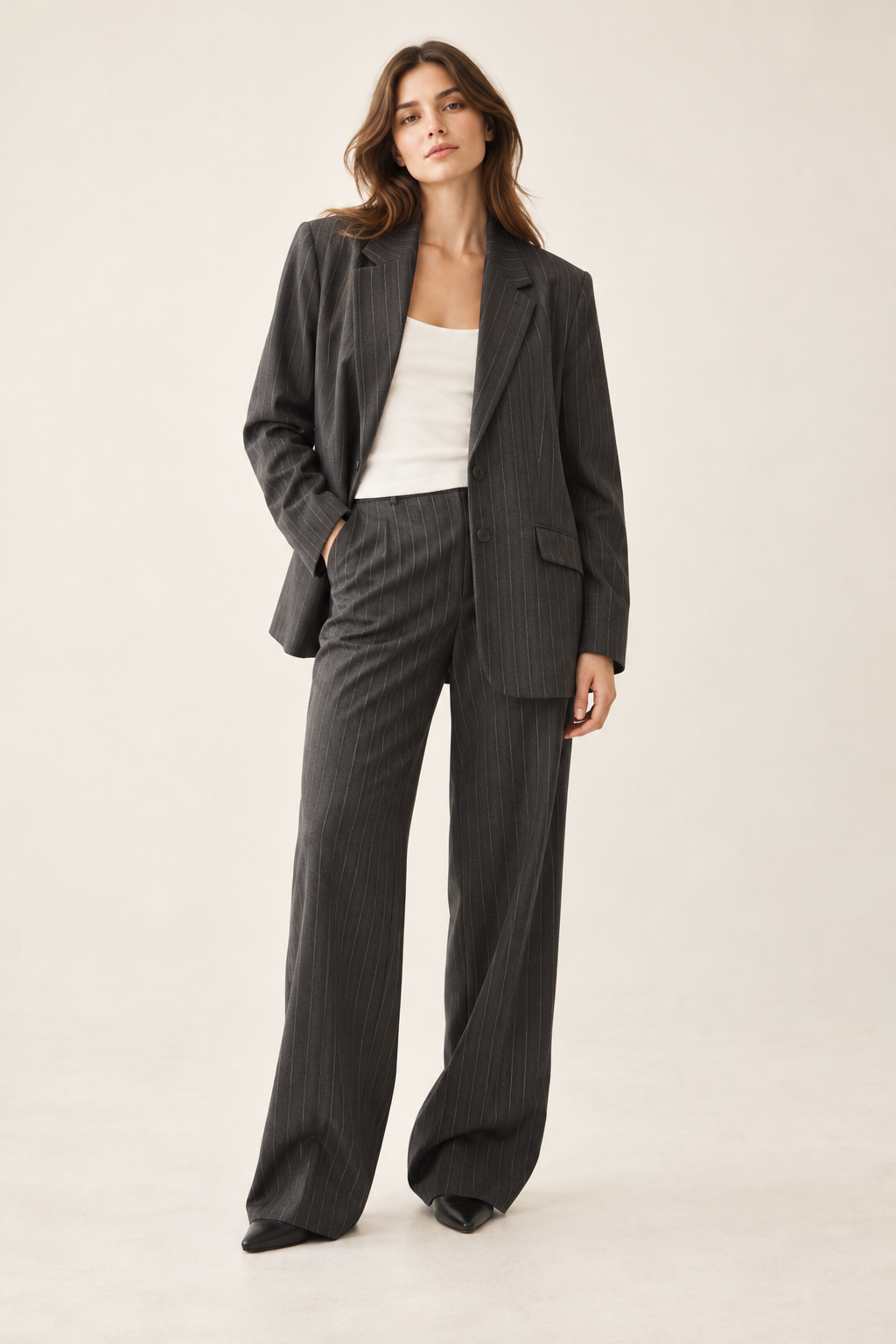 Imagen conceptual generada por IA de blazer gris oscuro de raya diplomática y corte amplio; no representa el artículo definitivo